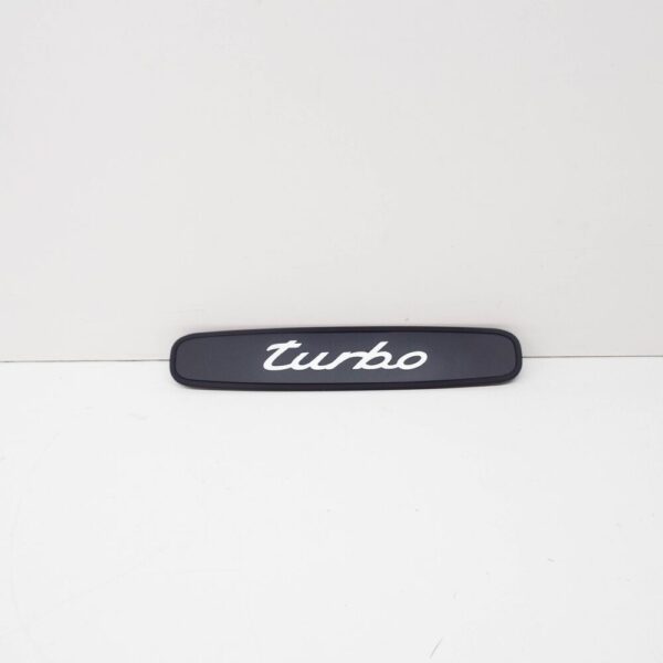 99655130500A03 - Porsche 911 996 rear trim "Turbo" logo black 99655130500A03 NEW ORIGINAL